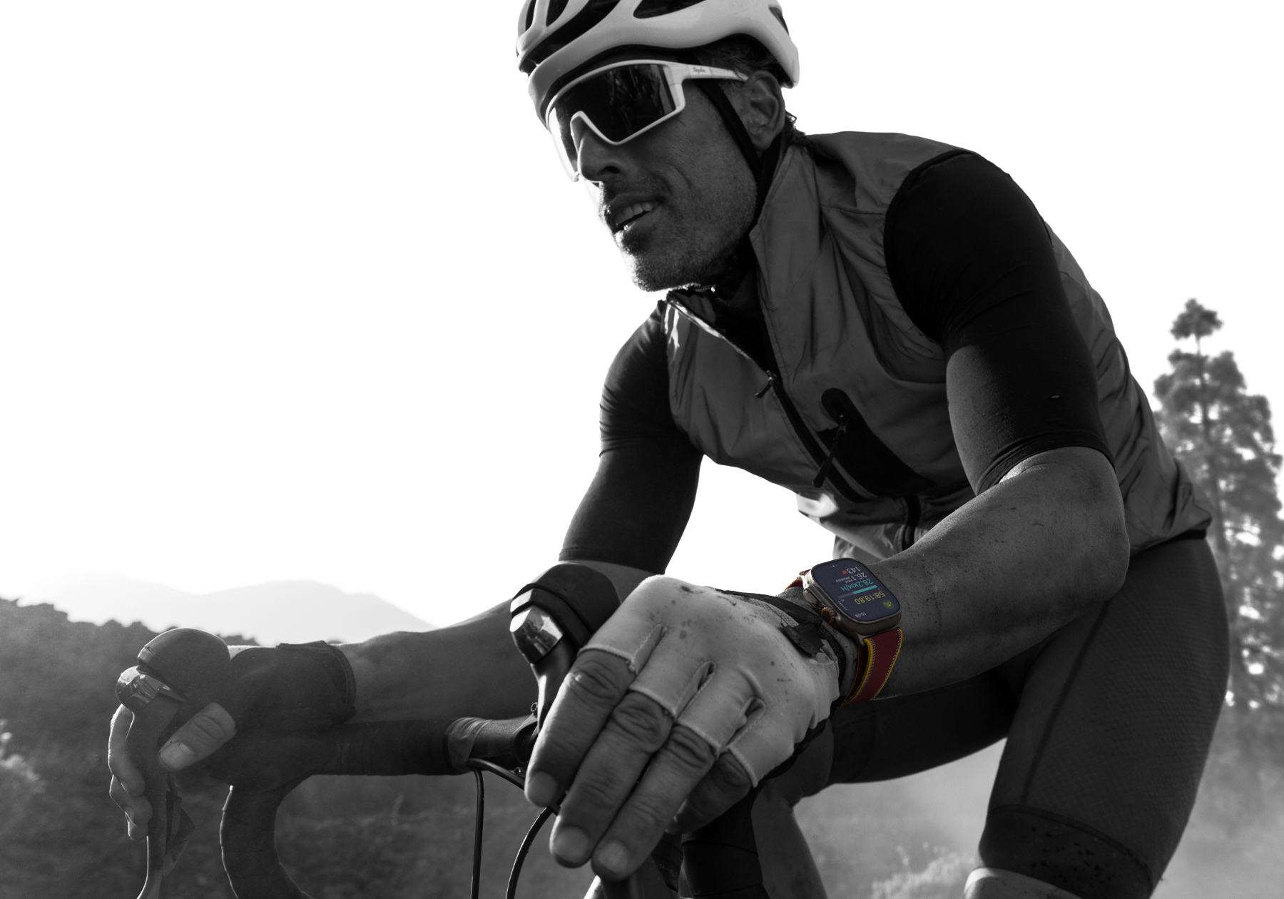 Una persona en bicicleta de carretera con un Apple Watch Ultra 4, la pantalla muestra métricas de ciclismo