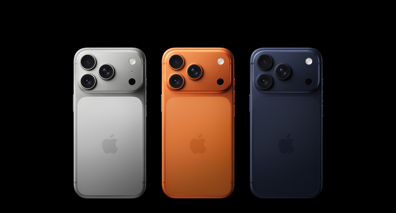 Tre iPhone 17 Pro-modeller vises bakfra i fargen sølv, kosmisk oransje og dypblå, med et Pro Fusion-kamerasystem øverst i venstre hjørne bestående av tre objektiver, mikrofon og blits, samt en Apple-logo i midten.