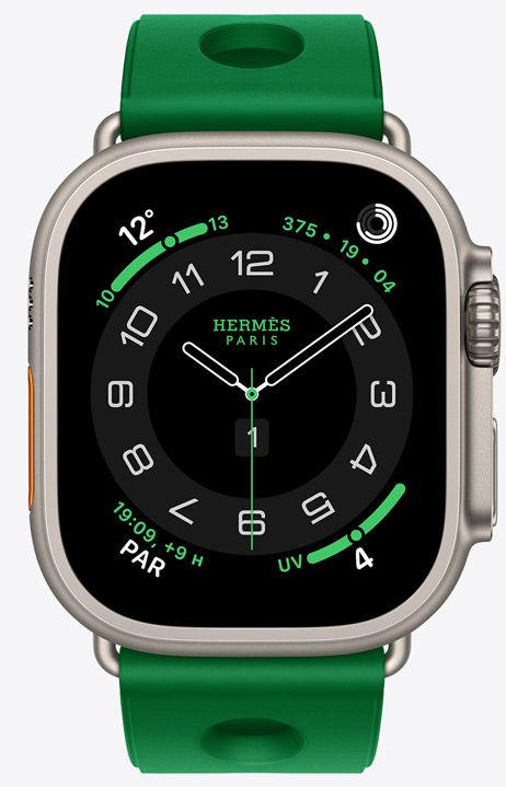 Apple Watch Hermès Ultra 4, cadran analogique Circulaire, (aiguilles des heures, des minutes et des secondes, complications : Météo, anneaux Activité, heure de Paris et Indice UV), boîtier en titane, finition naturelle, côté droit, Digital Crown, bouton latéral en saillie, associée au bracelet Scub’H Diving, Vert Vertigo (vert vif), caoutchouc moulé, découpes circulaires centrées