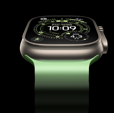 Tampilan close-up Apple Watch Ultra 3 Titanium Alami dengan latar belakang hitam. Layarnya menampilkan waktu dan info dinamis lainnya