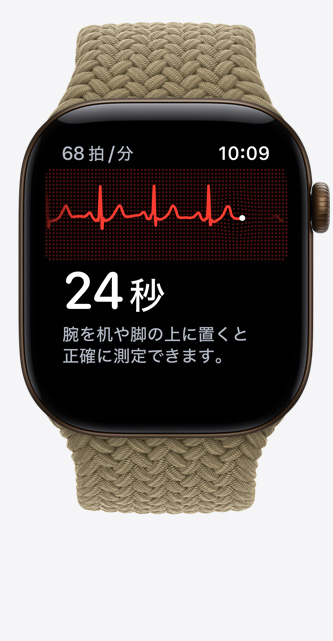 ダークブロンズのアルミニウムケースのApple Watch Series 12。心電図アプリに心拍の波形とタイマーが表示されていて、オリーブ（アースカラーのライトグリーン）のブレイデッドスポーツループが取りつけられている