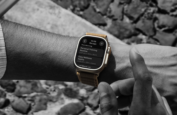 A person's wrist with Apple Watch Ultra 4, titanium case, natural color, Siri Recap notes, Alpine Loop band