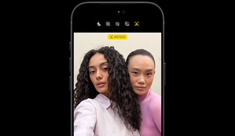 iPhone 18 Pro in Black, front-facing, showcasing two people with face tracking feature, demonstrates the Centre stage front camera feature