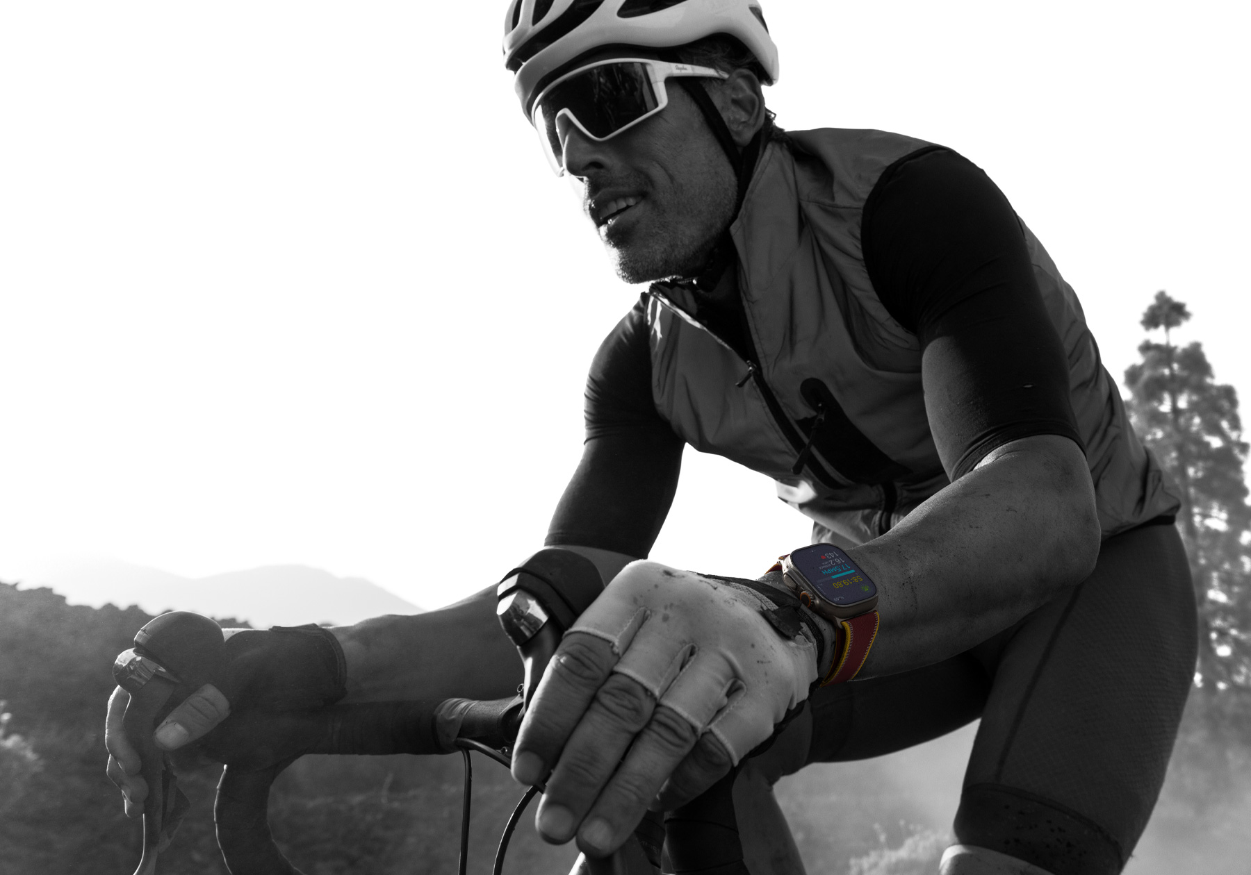 A person riding a road bike while wearing Apple Watch Ultra 4, screen shows cycling metrics