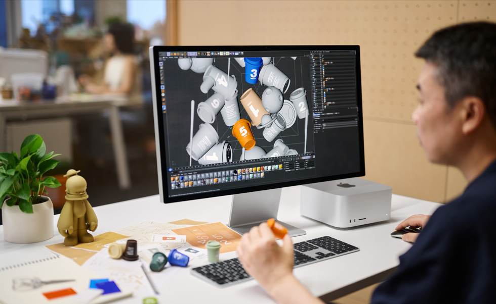 Een ontwerper gebruikt een Mac voor 3D-rendering.