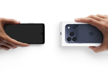 Deux mains échangeant un téléphone, un appareil Android sans boîte à gauche, un nouvel iPhone 17 Pro dans sa boîte à droite