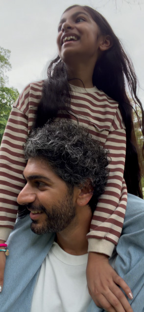 iPhone 17 waarmee gestabiliseerde video wordt opgenomen, in beeld een man die een jong meisje op zijn schouders heeft