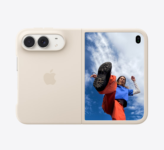 iPhone Duo, kleur Sterrenwit in siliconenhoesje in de kleur zand, liggende stand, volledig geopend, Dual Fusion-camera’s linksboven, hoesje bedekt de linkerachterkant en buitenrand van het buitendisplay aan de voorkant, op het buitendisplay aan de rechterkant is een afbeelding te zien van iemand die onder een blauwe lucht met witte wolken staat