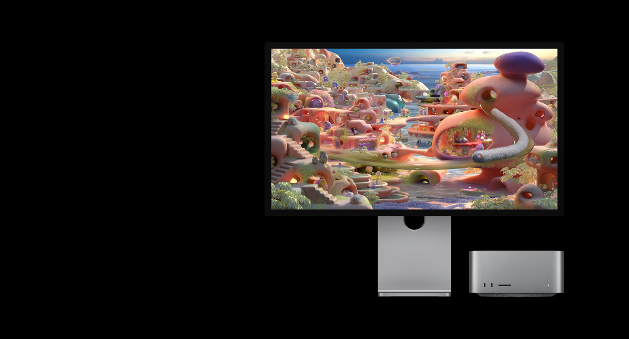 In einer Cartoon Landschaft auf dem Studio Display XDR mit dem Mac Studio darunter kommt eine wurmähnliche Kreatur aus einem Tunnel und gleitet über den Bildschirm