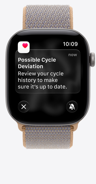 Apple Watch Series 12, screen shows Cycle Tracking in Health app, possible cycle deviation notification, aluminum case, space gray color connected to Sport Loop band, chambray blue color (light blue-gray)